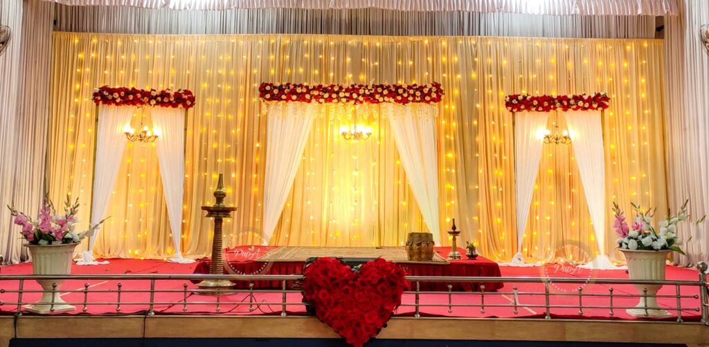 wedding decor done by pupa event planner using flowers and warm lights and putting a heart shape floral decor in the front